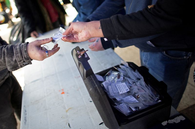 © Reuters. FILE PHOTO: Community members from the Drug User Liberation Front hand out clean, tested doses of drugs at a demonstration demanding the legalization and regulation of safe alternatives to the toxic street drug supply in Vancouver, British Columbia, Canada April 14, 2022. Picture taken April 14, 2022. REUTERS/Jesse Winter/File Photo