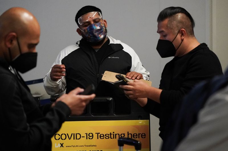 &copy; Reuters. FILE PHOTO: Travelers wait in line to get tests for the coronavirus disease (COVID-19) at a pop-up clinic at Tom Bradley International Terminal at Los Angeles International Airport, California, U.S., December 22, 2021. REUTERS/Bing Guan