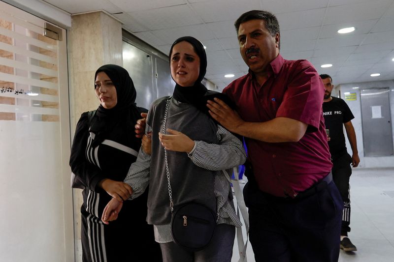 &copy; Reuters. أشخاص في مستشفى بعد مقتل امرأة فلسطينية في الخليل يوم الأربعاء. تصوير: موسى قواسمة - رويترز