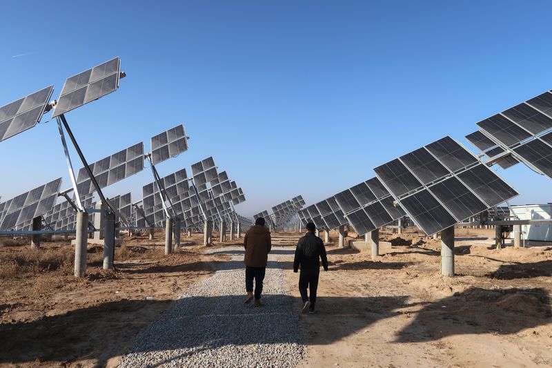 &copy; Reuters. FOTO DE ARCHIVO. Trabajadores caminan en una estación de energía solar en Tongchuan, provincia de Shaanxi, China. 11 de diciembre de 2019. REUTERS/Muyu Xu