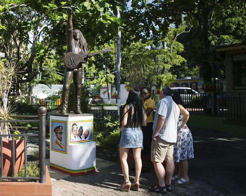 &copy; Reuters. Turistas observam estátua de Bob Marley do lado de fora do Museu  Bob Marley, em Kingston, na Jamaica
13/12/2013 REUTERS/Gilbert Bellamy 