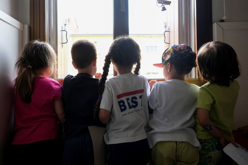 &copy; Reuters. Children pose by a window inside a nursery of Cartigliano, a small town in northern Italy where firms are offering money to families to help them enrol children in nursery schools, Italy May 27, 2022. REUTERS/Manuel Silvestri