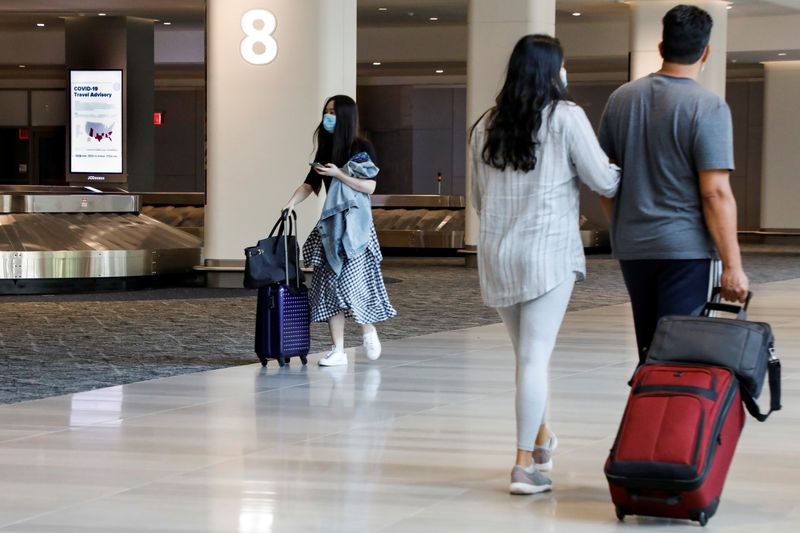 &copy; Reuters. FILE PHOTO: A sign alerts travelers to the danger of COVID-19 at LaGuardia Airport, during the outbreak of the coronavirus disease (COVID-19), in New York, U.S., June 29, 2020. REUTERS/Brendan McDermid