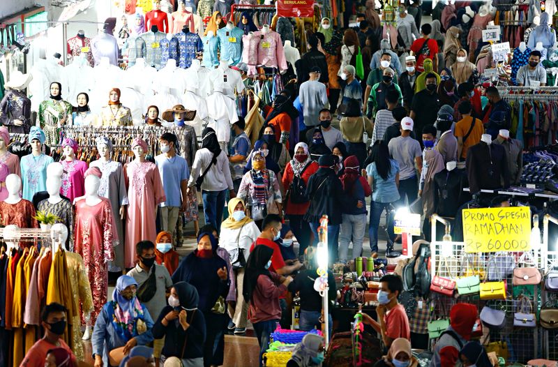 &copy; Reuters. FILE HPTO: People wearing protective face masks shopping in Tanah Abang textile market ahead of Eid al-Fitr festival amid the coronavirus disease (COVID-19) outbreak in Jakarta, Indonesia, May 3, 2021. REUTERS/Ajeng Dinar Ulfiana