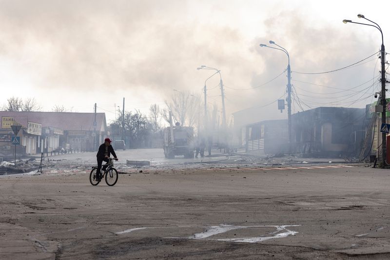 &copy; Reuters. شخص يركب دراجته أمام مبنى تم قصفه من قبل القوات الروسية في لوهانسك بأوكرانيا يوم 16 أبريل نيسان 2022. تصوير: ماركو دجوريكا - رويترز. 