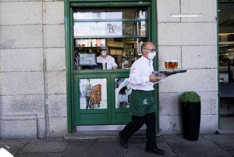 &copy; Reuters. FOTO DE ARCHIVO. Un camarero lleva una bandeja con cervezas en un barrio comercial de Madrid, España. 27 de julio de 2021. REUTERS/Juan Medina