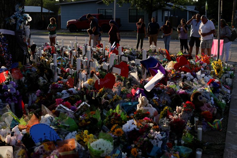 &copy; Reuters. FILE PHOTO: People pay their respects at the Robb Elementary School memorial, where a gunman killed 19 children and two teachers in the deadliest U.S. school shooting in nearly a decade, in Uvalde, Texas, U.S. May 30, 2022. REUTERS/Marco Bello