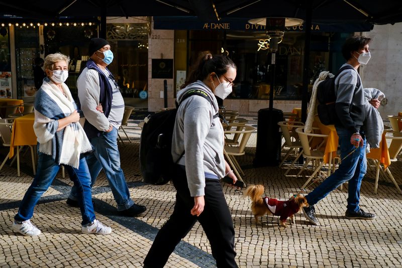 &copy; Reuters. FOTO DE ARCHIVO: Varias personas con mascarilla caminan por una calle de Lisboa, Portugal, el 21 de diciembre de 2021. REUTERS/Pedro Nunes