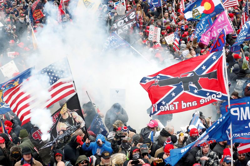 &copy; Reuters. FILE PHOTO: Tear gas is released into a crowd of protesters, with one wielding a Confederate battle flag that reads "Come and Take It," during clashes with Capitol police at a rally to contest the certification of the 2020 U.S. presidential election resul
