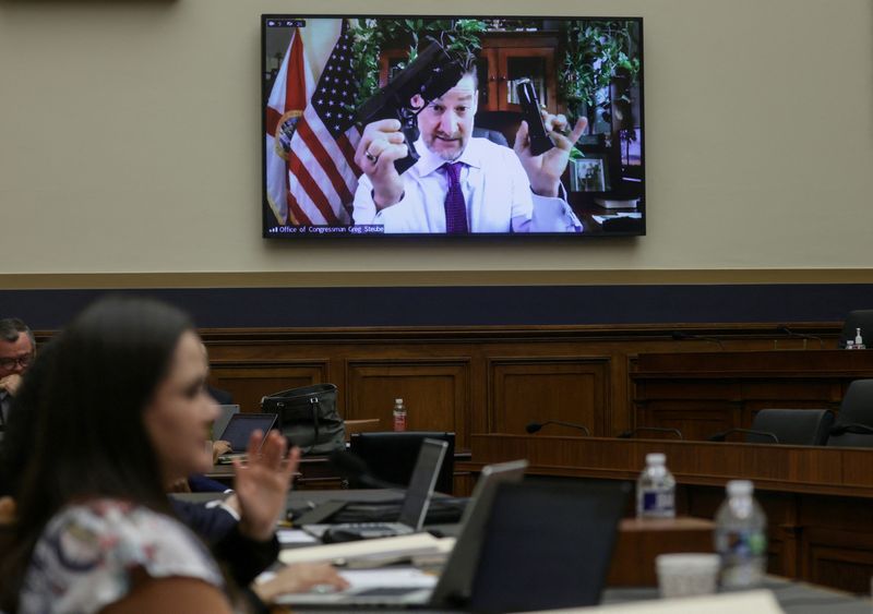 © Reuters. U.S. Representative Greg Steube (R-FL) holds up a handgun as he speaks via video link during the House Judiciary Committee hearing to markup the 