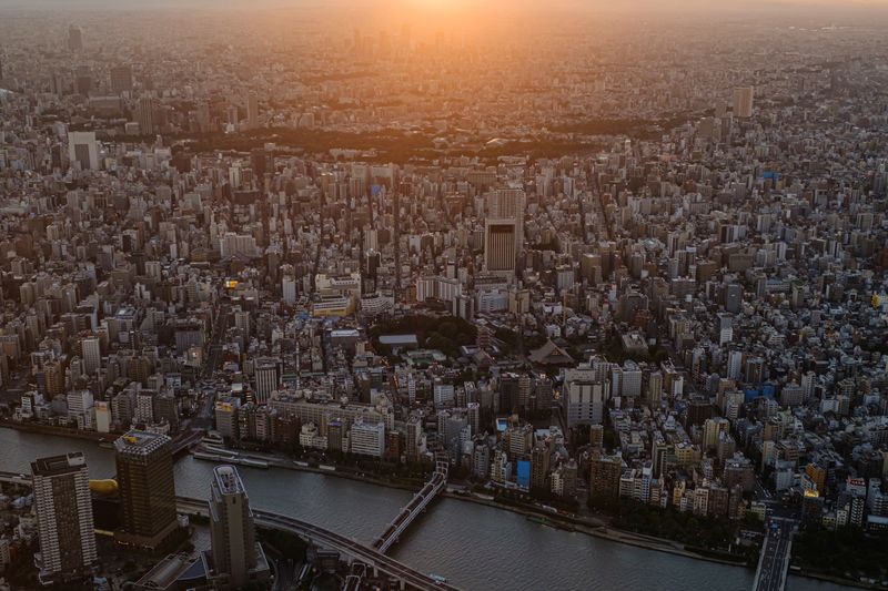 &copy; Reuters. FILE PHOTO: The sun sets over office and residential buildings seen from the observation deck of Tokyo Skytree, the world's tallest broadcasting tower, in Tokyo, Japan, August 18, 2021. REUTERS/Marko Djurica