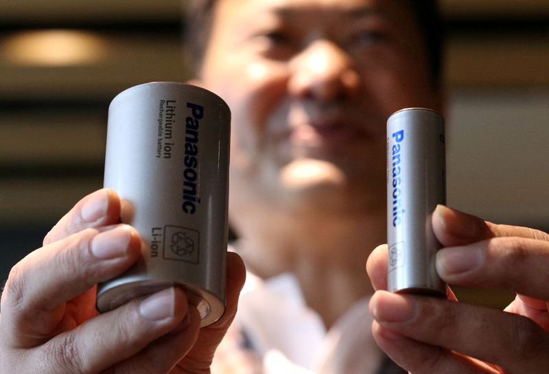 © Reuters. FILE PHOTO: Kazuo Tadanobu, CEO of Panasonic's Energy Company holds a prototype of the 4680 format battery cell (L) next to the current 2170 battery supplied to Tesla Inc during a news conference in Tokyo, Japan October 25, 2021.REUTERS/Tim Kelly/File Photo