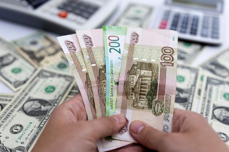 &copy; Reuters. Woman holds Russian Roubles in front of U.S. Dollar banknotes in this illustration taken May 30, 2022. REUTERS/Dado Ruvic/Illustration