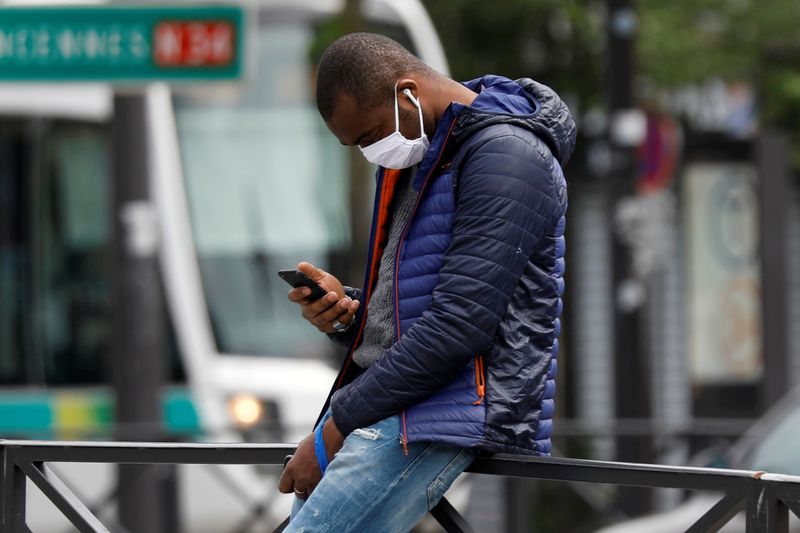 &copy; Reuters. FILE PHOTO: A man, wearing a protective face mask, checks his mobile phone during a lockdown imposed to slow the rate of the coronavirus disease (COVID-19) in Paris, France, April 28, 2020.  REUTERS/Charles Platiau