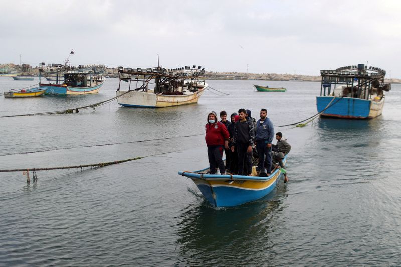 &copy; Reuters. FILE PHOTO: Palestinian fishermen riding on a boat make their way back after Israel restricted Palestinian fishing zone in response to Palestinian rockets, at the seaport of Gaza City April 26, 2021. REUTERS/Mohammed Salem/File Photo