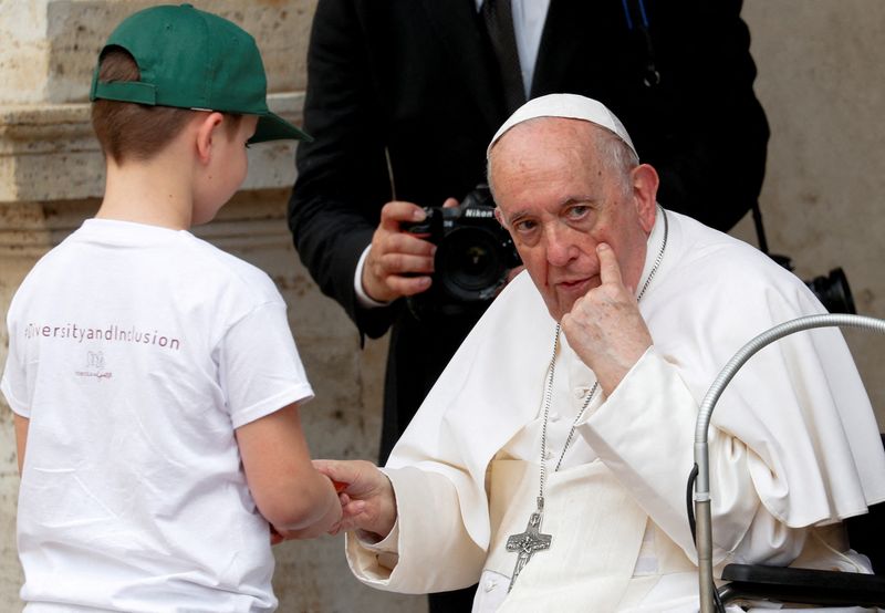 &copy; Reuters. البابا فرنسيس يعطي طفلا سبحة أثناء لقائه مع أطفال ذوي إعاقة من أوكرانيا في الفاتيكان يوم السبت. تصوير: ريمو كاسيللي - رويترز.