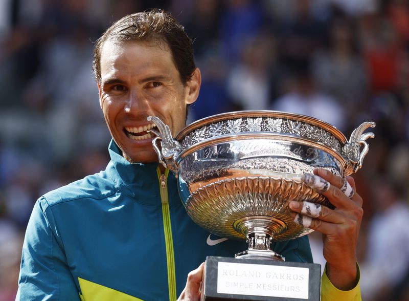 © Reuters. Tennis - French Open - Roland Garros, Paris, France - June 5, 2022 Spain's Rafael Nadal bites the trophy to celebrate winning the men's singles final against Norway's Casper Ruud REUTERS/Yves Herman