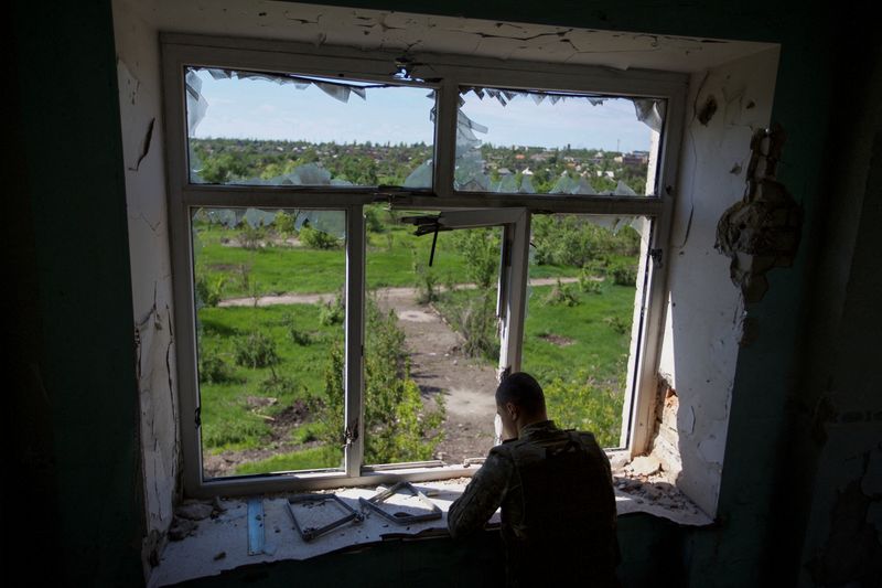 &copy; Reuters. FOTO DE ARCHIVO. Un militar ucraniano inspecciona la zona desde un edificio dañado por un ataque militar ruso, mientras continúa el ataque de Rusia a Ucrania, en la ciudad de Marinka, en la región de Donetsk, Ucrania. 28 de mayo de 2022. REUTERS/Anna K