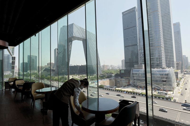 &copy; Reuters. FILE PHOTO: A staff member wipes a seat at a restaurant, following a ban on dine-in services amid the coronavirus disease (COVID-19) outbreak, in the Central Business District (CBD) of Beijing, China June 2, 2022. REUTERS/Tingshu Wang