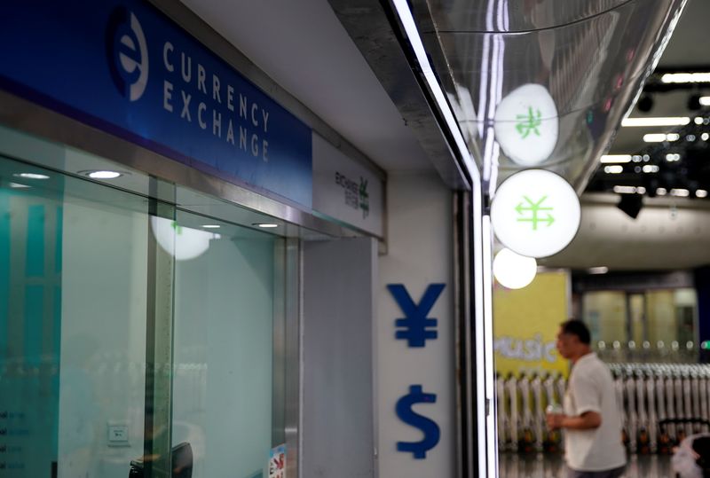 &copy; Reuters. Símbolos de iuan e dólar em casa de câmbio de Xangai, China
08/08/2019. REUTERS/Aly Song