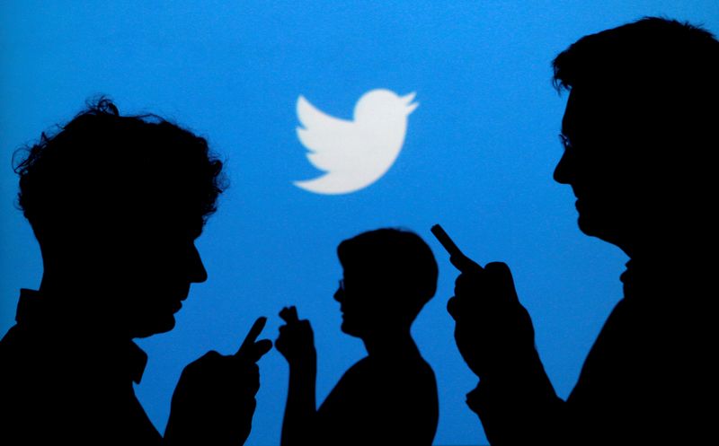 &copy; Reuters. FILE PHOTO: People holding mobile phones are silhouetted against a backdrop projected with the Twitter logo in this illustration picture taken September 27, 2013. REUTERS/Kacper Pempel/Illustration