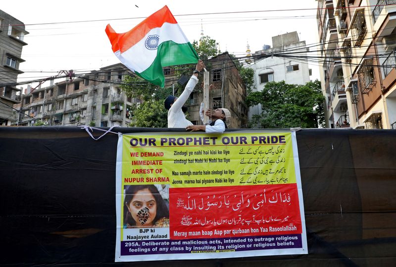 © Reuters. People erect the national flag of India before the start of a protest demanding the arrest of Bharatiya Janata Party (BJP) member Nupur Sharma for her blasphemous comments on Prophet Mohammed, in Kolkata, India, June 7, 2022. REUTERS/Rupak De Chowdhuri