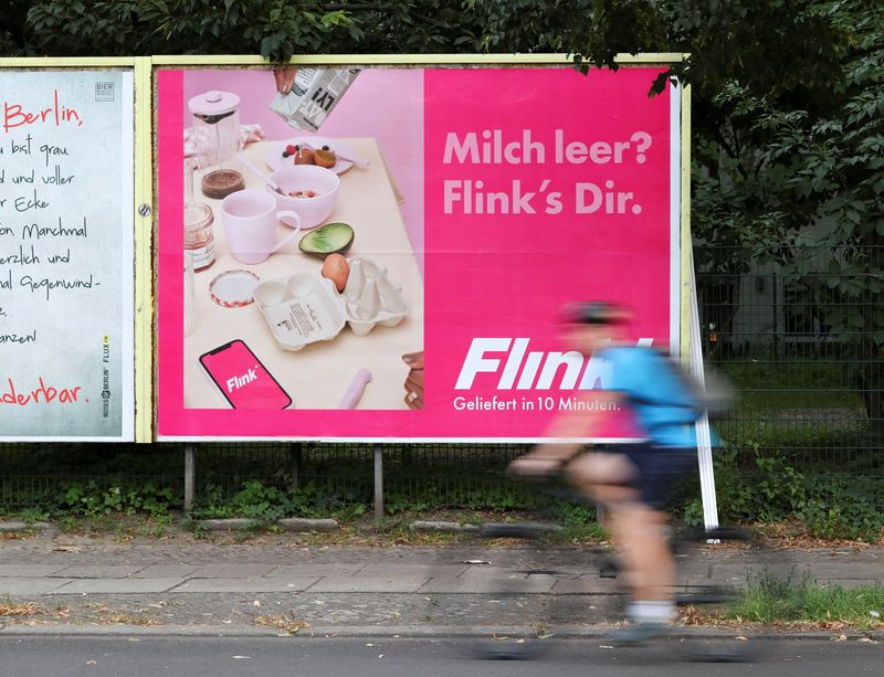 &copy; Reuters. FILE PHOTO: A cyclist drives past an advertisement promoting the grocery delivery company "Flink", in Berlin, Germany, August 13, 2021. REUTERS/Christian Mang/File Photo