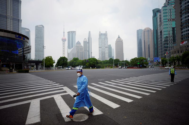 &copy; Reuters. FILE PHOTO: A worker in a protective suit walks on a pedestrian crossing at an intersection in Lujiazui financial district, after the lockdown placed to curb the coronavirus disease (COVID-19) outbreak was lifted in Shanghai, China June 2, 2022. REUTERS/A