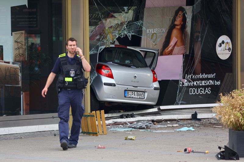 &copy; Reuters. Un poliziotto davanti a una vetrina sfondata da un'auto a Berlino. REUTERS/Fabrizio Bensch