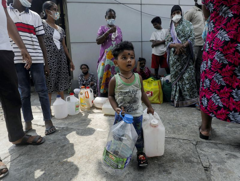 &copy; Reuters. FILE PHOTO: A child waiting to buy kerosene with his mother in the morning plays with cans, during a shortage of domestic gas as a result of country's economic crisis, at a fuel station in Colombo, Sri Lanka March 18, 2022. REUTERS/Dinuka Liyanawatte/File