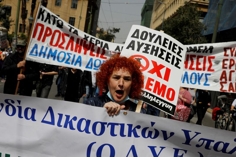 &copy; Reuters. FOTO DE ARCHIVO: Una mujer sostiene una pancarta y un cartel, mientras participa en una protesta durante una huelga de 24 horas por los altos precios y los bajos salarios en Atenas, Grecia, el 6 de abril de 2022. REUTERS/Costas Baltas