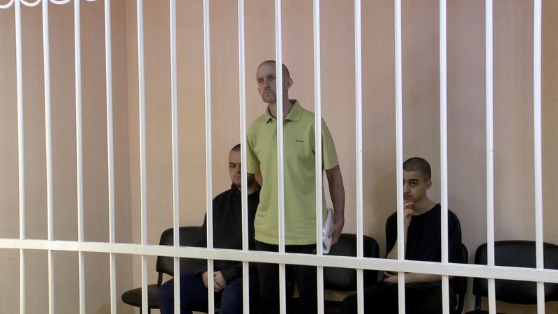 &copy; Reuters. البريطانيان أيدن أسلين وشون بينر والمغربي إبراهيم سعدون في قفص بقاعة المحكمة في دونيتسك بأوكرانيا يوم الثلاثاء. صورة لرويترز محظور إعادة ب