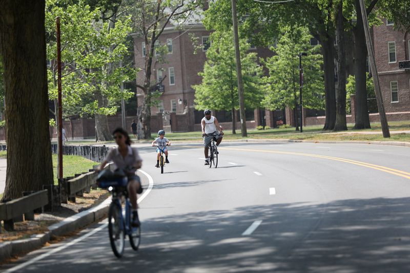 &copy; Reuters. FILE PHOTO: People ride bikes, as the U.S. East Coast is hit by a heat wave, on Memorial Drive in Cambridge, Massachusetts, U.S. May 22, 2022. REUTERS/Katherine Taylor