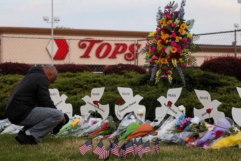 &copy; Reuters. FILE PHOTO: A man prays at a memorial at the scene of a weekend shooting at a Tops supermarket in Buffalo, New York, U.S. May 19, 2022.  REUTERS/Brendan McDermid//File Photo