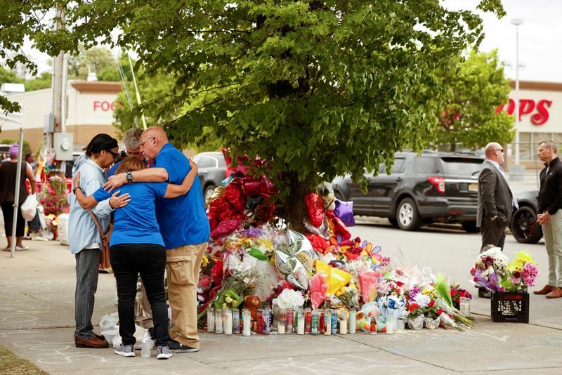 © Reuters. FILE PHOTO: People pray at a memorial at the scene of a weekend shooting at a Tops supermarket in Buffalo, New York, U.S. May 20, 2022.  REUTERS/Lindsay DeDario/File Photo