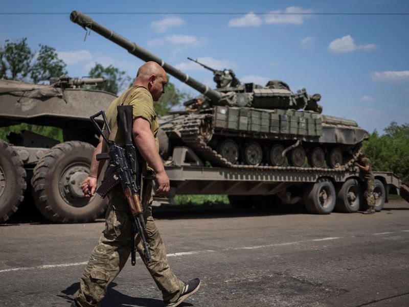 &copy; Reuters. FOTO DE ARCHIVO. Un militar ucraniano camina cerca de un camión militar con un tanque en la calle, en medio de la invasión rusa de Ucrania, en la región de Donetsk, Ucrania. 8 de junio de 2022. REUTERS/Gleb Garanich