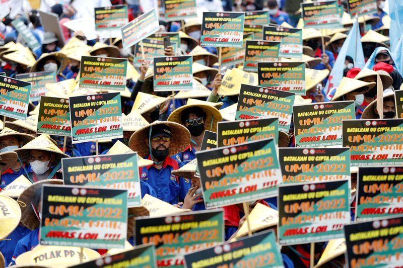 &copy; Reuters. FILE PHOTO: Members of Indonesian trade unions hold placards during a protest against the government's labor reforms, as Indonesia's Constitutional Court reads the verdict on a judicial review filed on the controversial 'omnibus' or job creation law in Ja