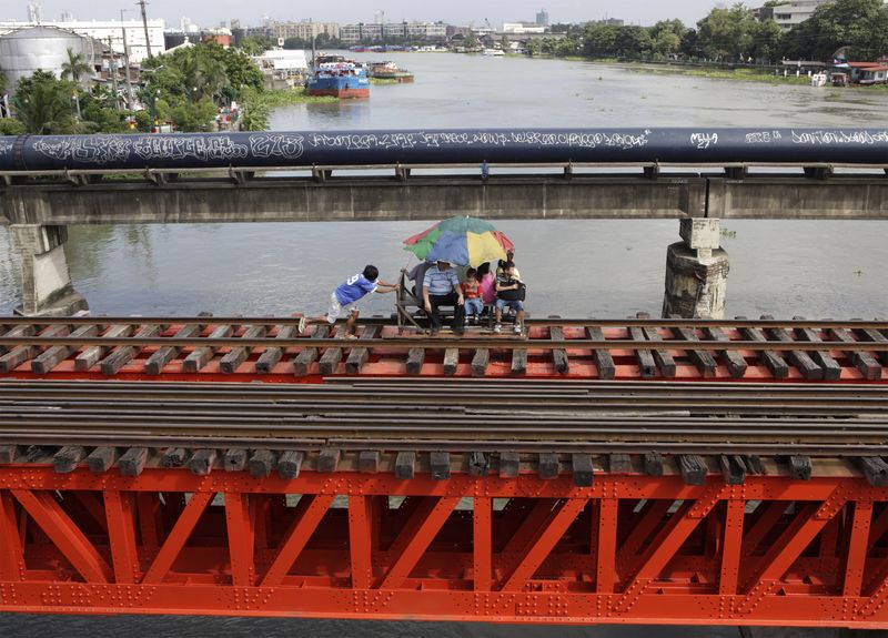 &copy; Reuters. FILE PHOTO: Commuters ride a makeshift trolley in a railway in Metro Manila July 26, 2009. The foot-powered trolleys, made out of light materials such as bamboo, can be easily removed from the tracks when an oncoming train approaches. REUTERS/John Javella