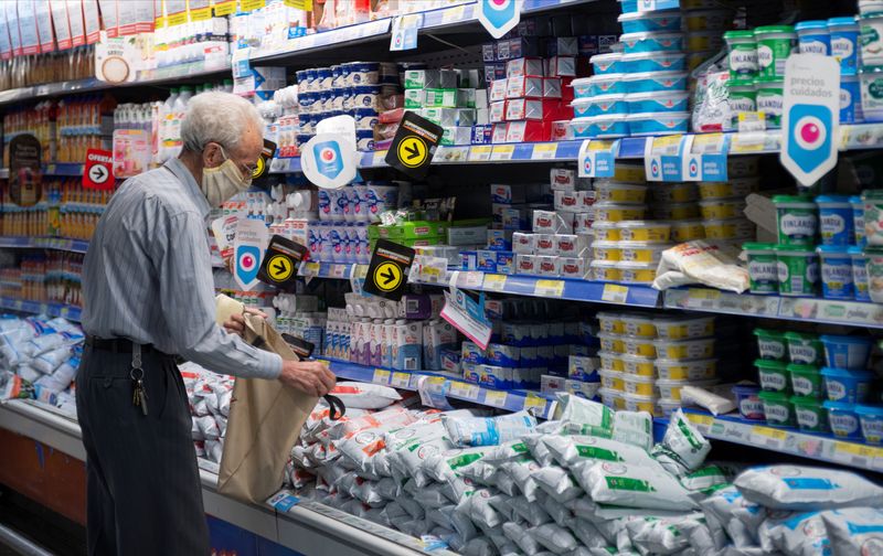 &copy; Reuters. FILE PHOTO: A man stands next to dairy products in a supermarket in downtown Buenos Aires, Argentina November 8, 2021. REUTERS/Mariana Nedelcu