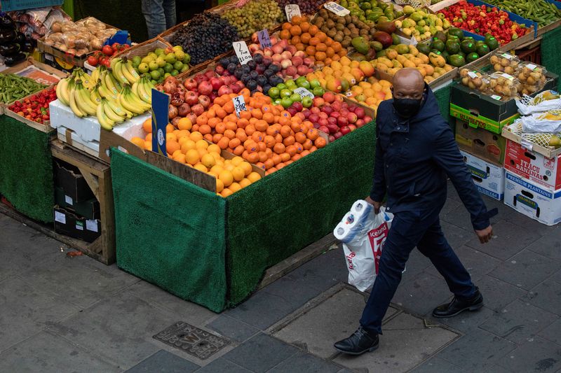 &copy; Reuters. FILE PHOTO: A man walks past a fruit and vegetable shop at Brixton Market, amid the spread of the coronavirus disease (COVID-19), in London, Britain, September 27, 2020. REUTERS/Simon Dawson