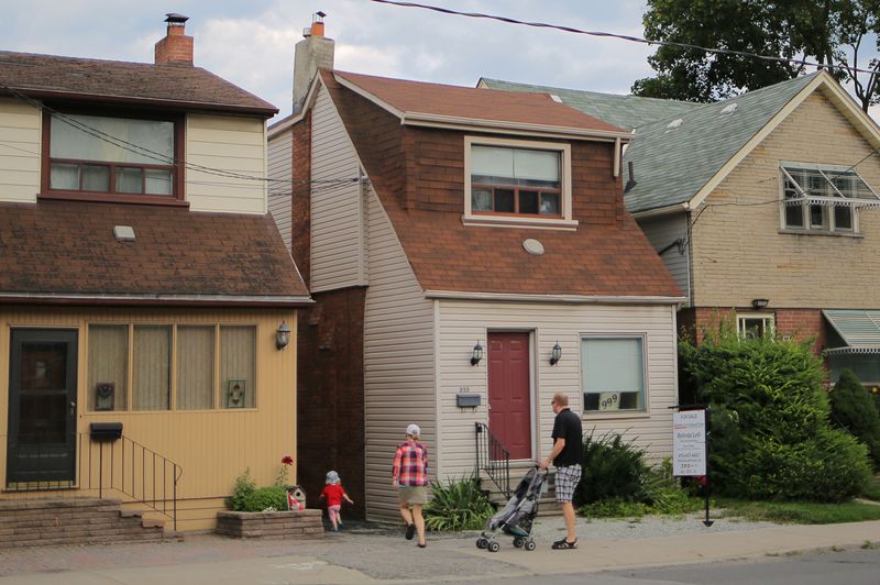 &copy; Reuters. FILE PHOTO: A family passes a house for sale listed at a price of $999,000 ($799,000 USD) on Mount Pleasant Road in Toronto, Ontario, Canada August 6, 2017. REUTERS/Chris Helgren