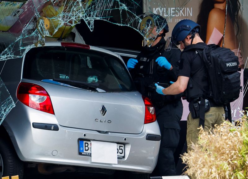 &copy; Reuters. ضباط شرطة يقفون بجوار السيارة التي دهس سائقها مجموعة من المارة في برلين يوم الأربعاء. تصوير: ميشيل تانتوسي - رويترز.