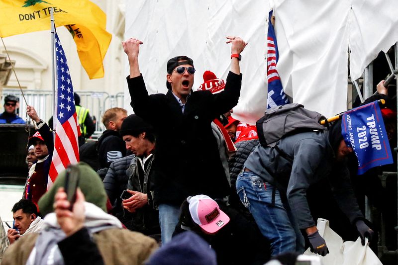 © Reuters. FILE PHOTO: A man, identified as Ryan Kelley in a sworn statement by an FBI agent, gestures as supporters of U.S. President Donald Trump make their way past barriers at the U.S. Capitol during a protest against the certification of the 2020 U.S. presidential election results by the U.S. Congress, in Washington, U.S., January 6, 2021. REUTERS/Jim Urquhart/File Photo     