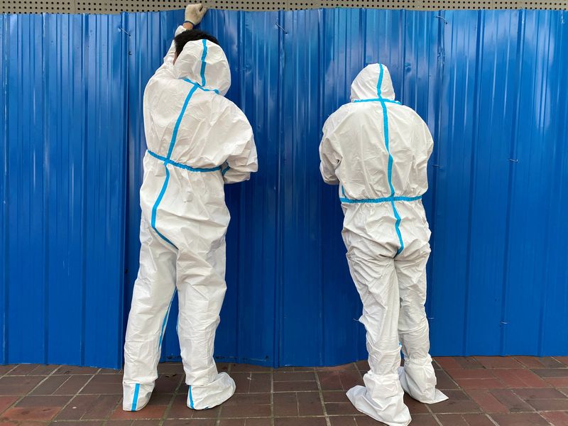 &copy; Reuters. Workers in protective suits set up barriers outside a building, following the coronavirus disease (COVID-19) outbreak, in Shanghai, China June 9, 2022. REUTERS/Andrew Galbraith