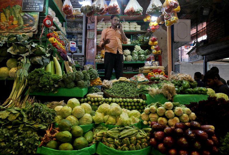 &copy; Reuters. FILE PHOTO: Debashis Dhara, a vegetable vendor, speaks on his mobile phone at a retail market area in Kolkata, India, March 22, 2022. REUTERS/Rupak De Chowdhuri