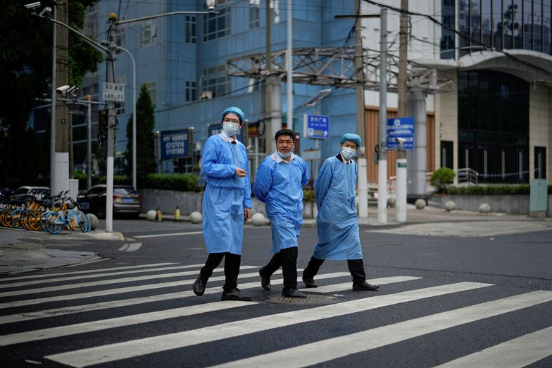 &copy; Reuters. Pessoas em trajes de proteção atravessam a rua em Xangai em meio à pandemia de Covid-19
26/05/2022 REUTERS/Aly Song