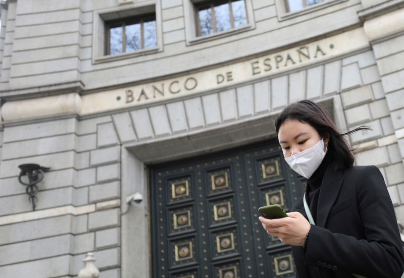 &copy; Reuters. FOTO DE ARCHIVO: Una mujer con mascarilla pasa frente al edificio del Banco de España en Barcelona, Cataluña, España, el 14 de marzo de 2020. REUTERS/Nacho Doce