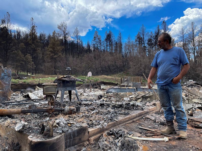 &copy; Reuters. Daniel Encinias stands next to the ruins of his home destroyed by the Hermits Peak Calf Canyon fire in Tierra Monte, New Mexico, U.S., June 9, 2022.  Picture taken June 9, 2022. REUTERS/Andrew Hay