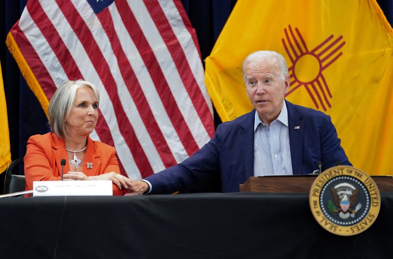 © Reuters. U.S. President Joe Biden reaches for the hand of New Mexico Governor Michelle Lujan during a wildfire briefing at the Emergency Operation Center in Santa Fe, New Mexico, U.S. June 11, 2022. REUTERS/Kevin Lamarque     
