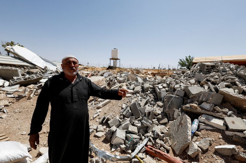 &copy; Reuters. الفلسطيني محمود علي النجاجرة يشير إلى منزله المهدم في مسافر يطا في الضفة الغربية يوم 31 مايو أيار 2022. تصوير: موسى قواسمة - رويترز.